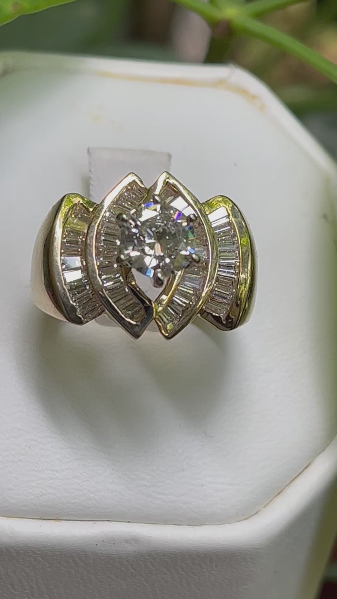 This ring is done in 14kt yellow gold. It has a 1.18ct round stone in the center and is surrounded by 2.0kt in baguette diamonds. The brilliance and color are excellent. This ring is a size 8. Standard shipping is included